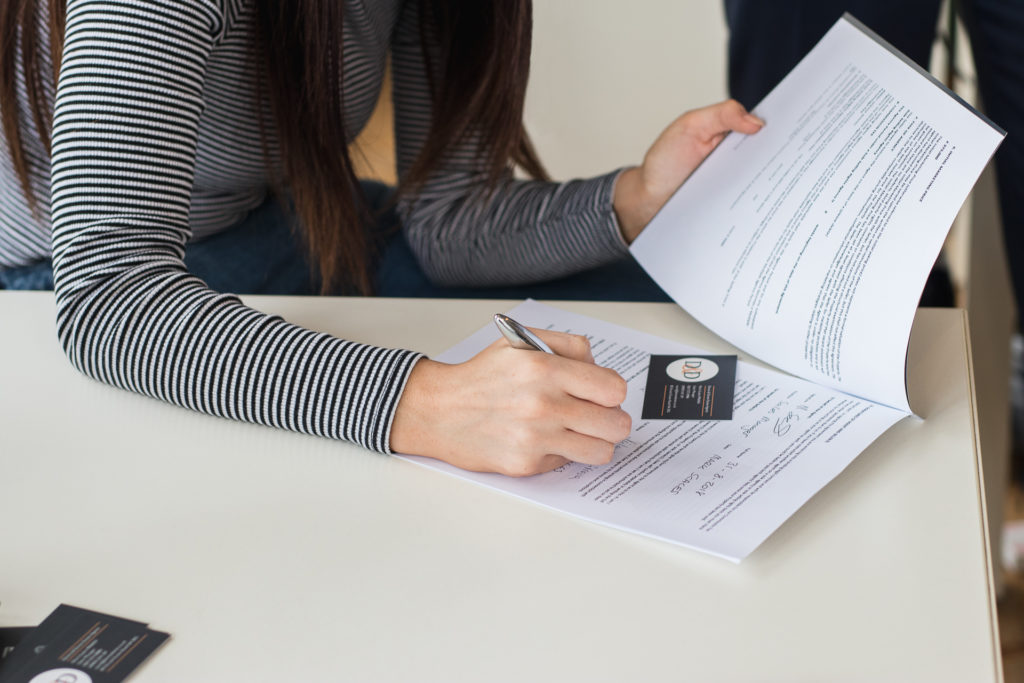 A photo of a Davies & Davies employee filling out the paper work for arranging Surveyor's Reports.