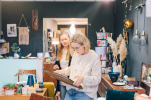 Two women sorting through furniture and their belongings