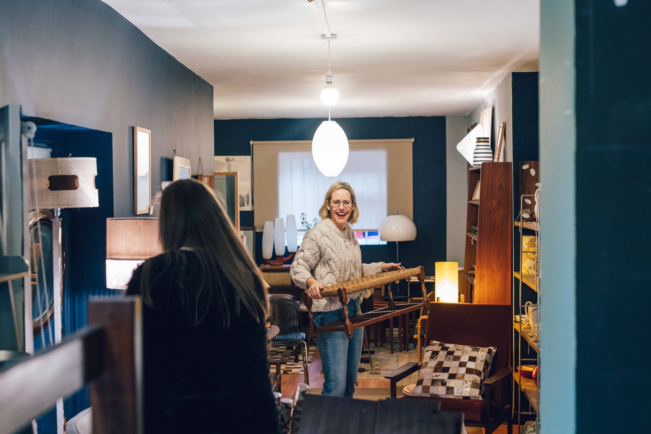 Women moving around furniture and laughing