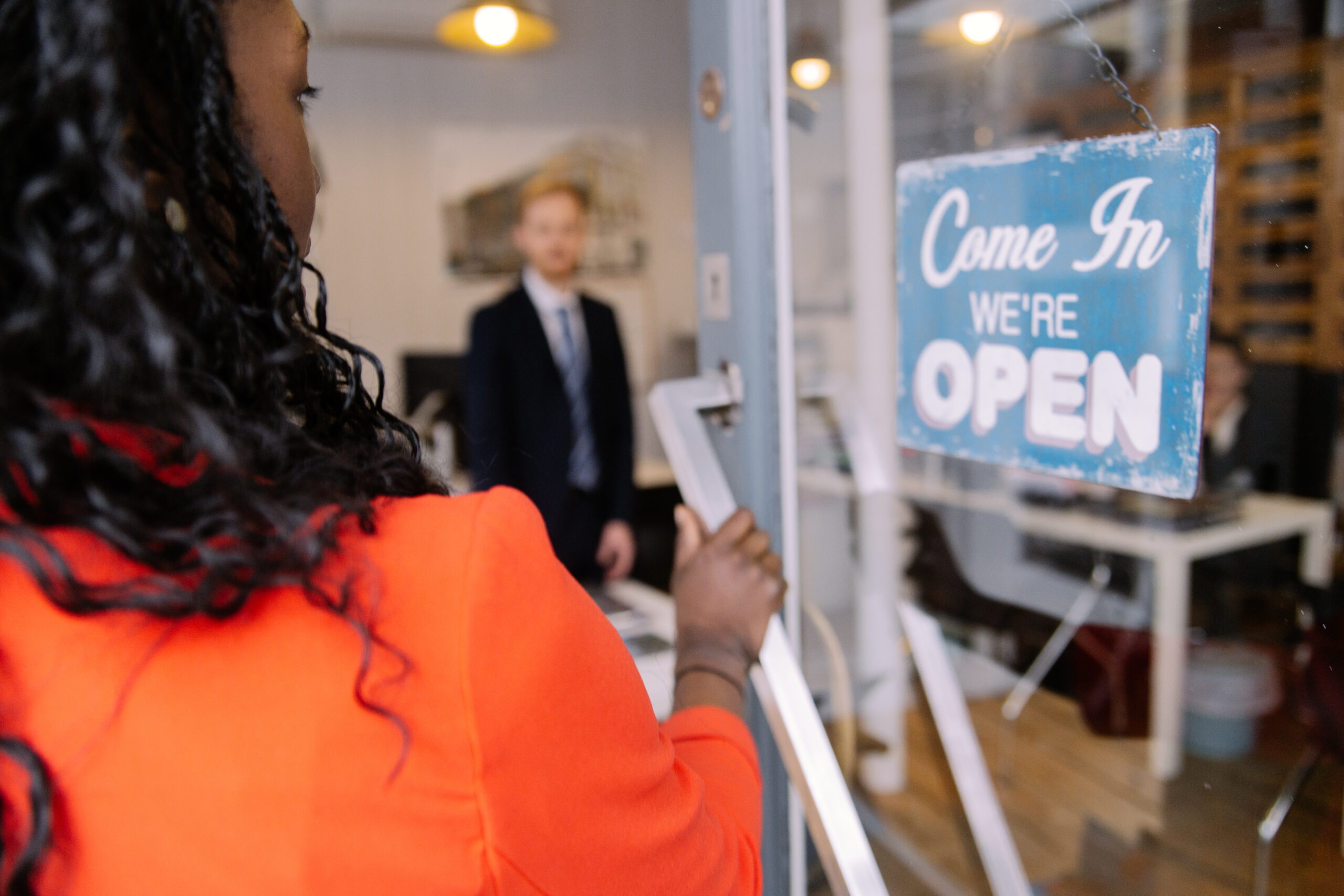 A picture of someone entering the Davies & Davies office with a sign on the door saying 'come in we're open.'