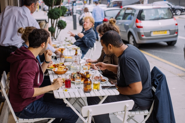 People eating in the outdoor area of a local restaurants in Harringay