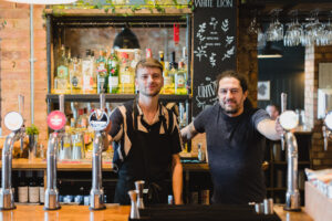 A picture of two employees from the White Lion smiling at the camera.