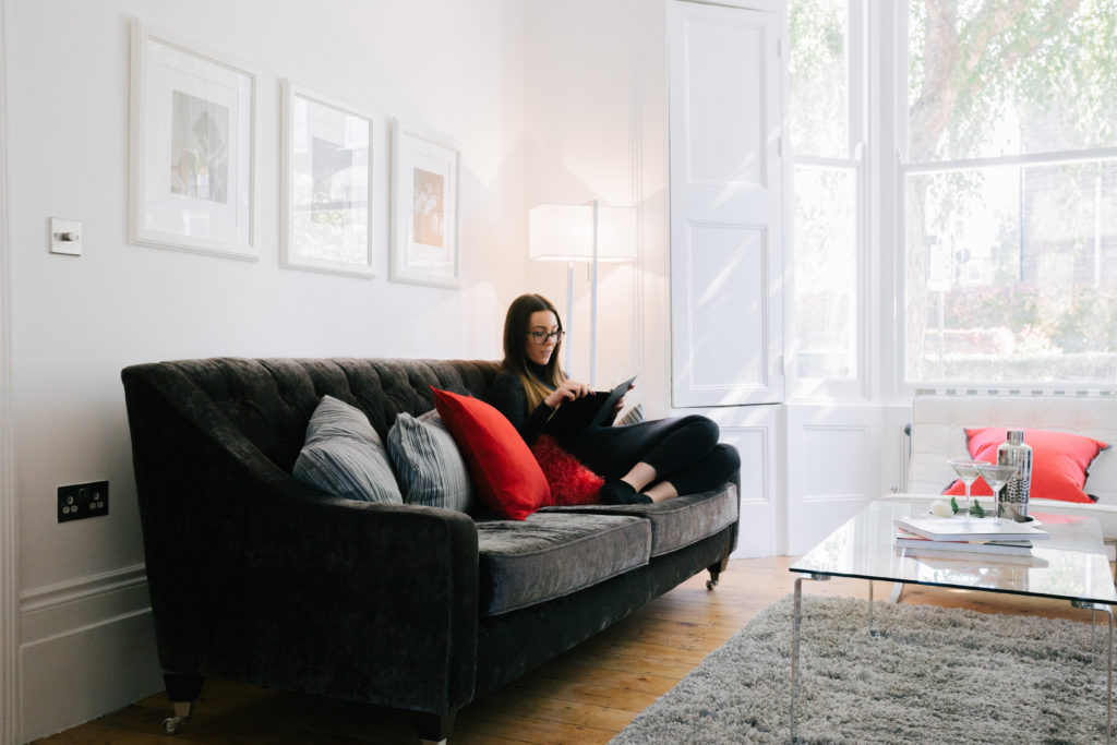 A tenant sitting on the sofa in their home.