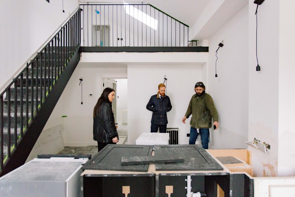 A photograph of a surveyor and homeowners discussing a property extension.