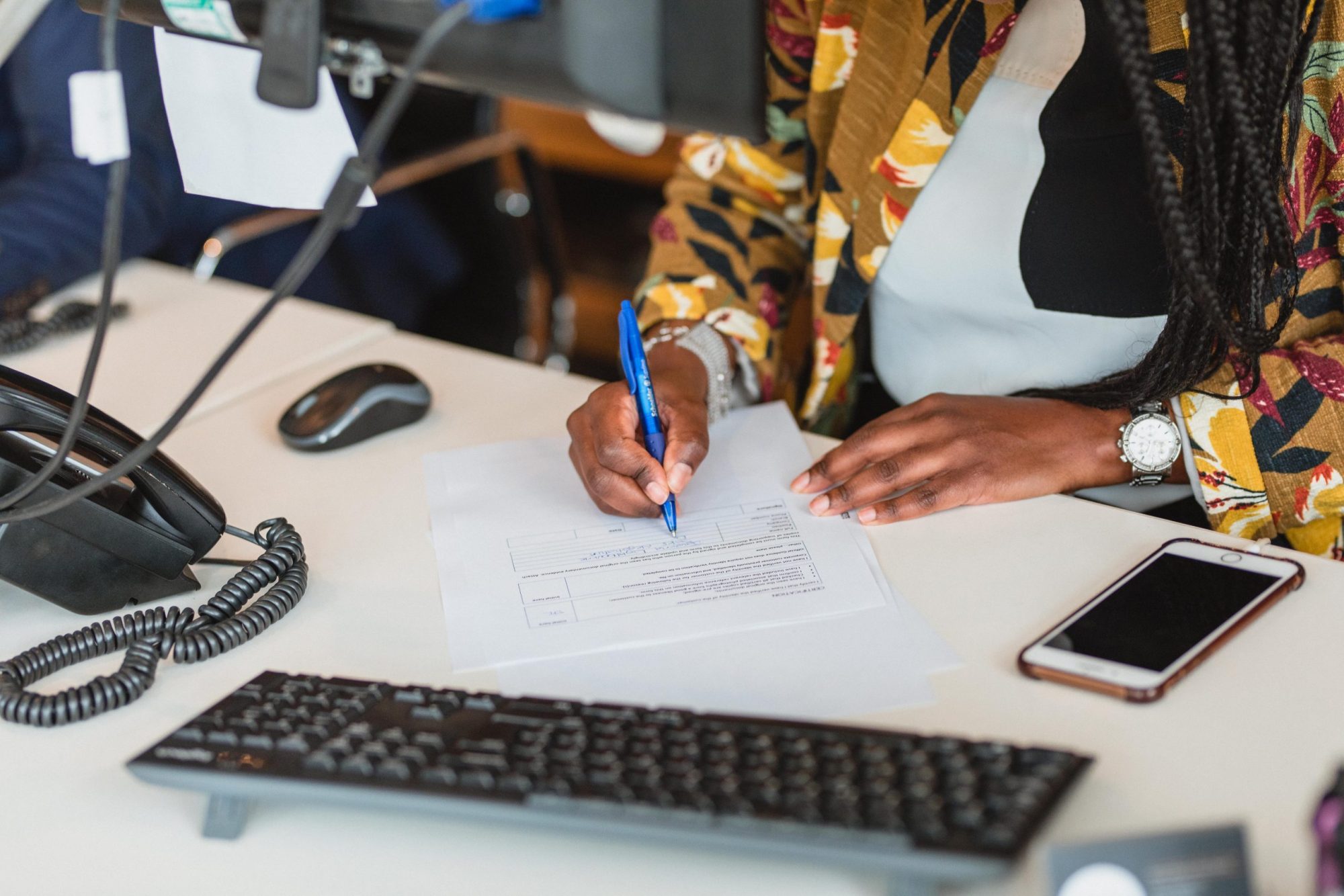 A picture of a Davies & Davies employee at her desk finalising a contract with a client. 