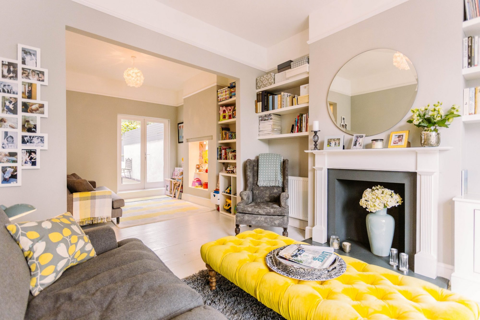 A picture of very cosy looking open plan living room with a bright yellow padded table 