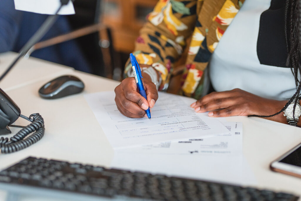 Photo of a member of Davies & Davies filling out a tenant referencing form with a prospective renter.