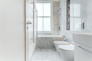 A photo of an immaculately presented modern bathroom with a marble finish floor to ceiling tiles 