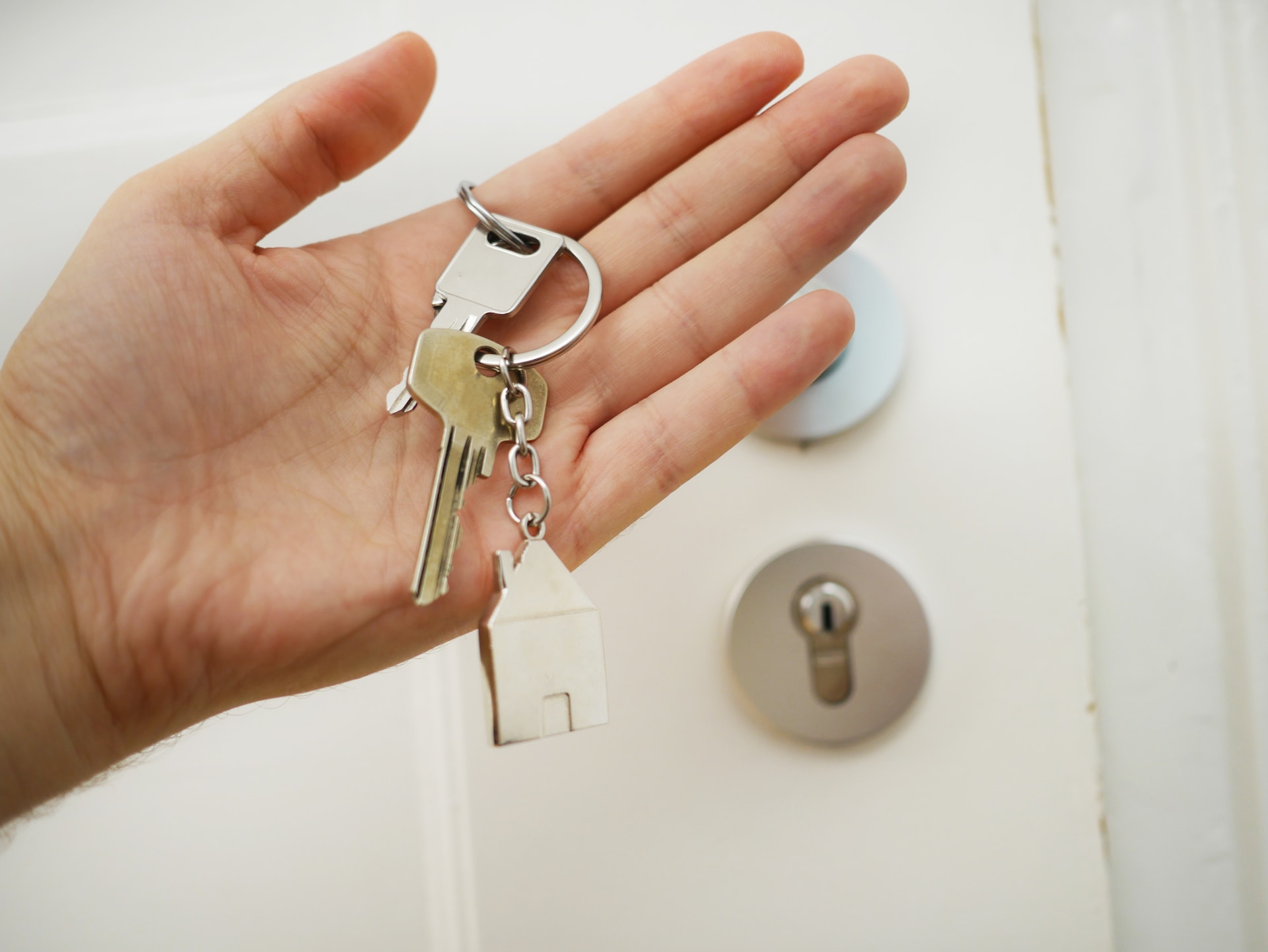 Photograph of a hand holding a set of keys outside a door