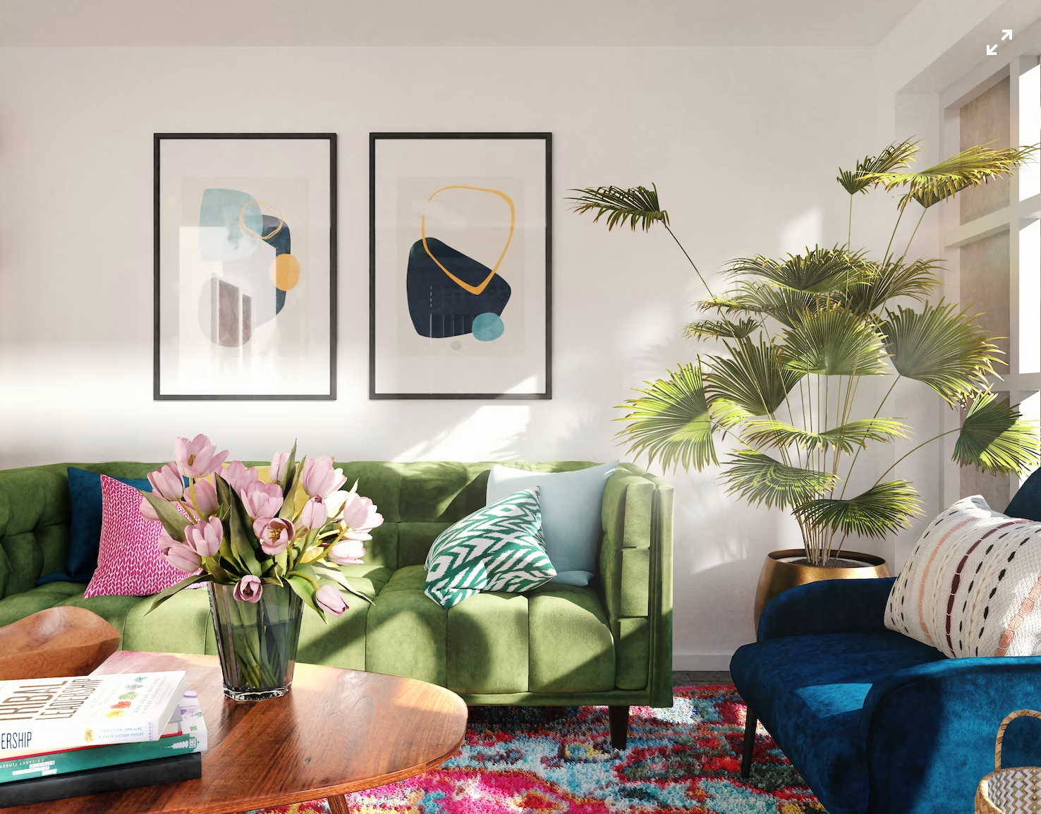 A photo of a living room with a green sofa, artwork and plant